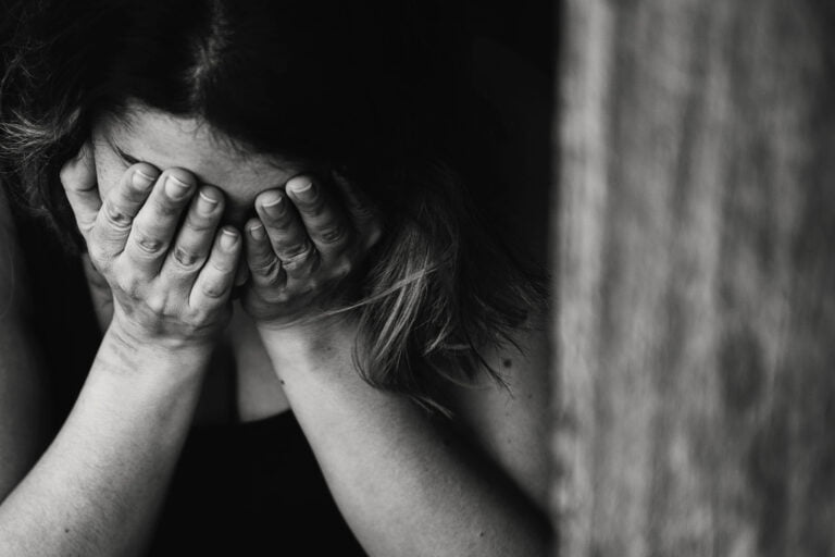 a young woman has her head in her hands