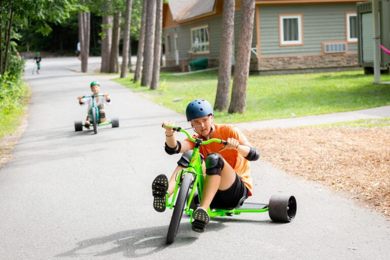 Two young people ride drift trikes