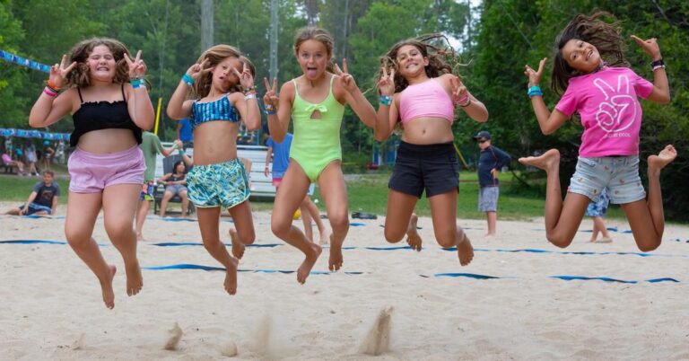 Summer camp guests jump in the air for a silly photo