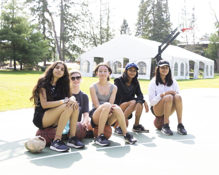 Female guests posing for a photo on the basketball court