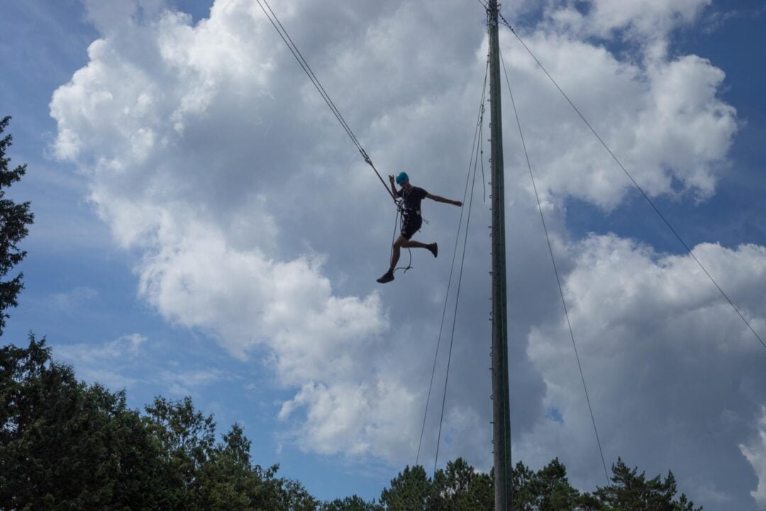 silhouette of a teenager on a giant swing