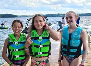 Three girls in life jackets
