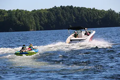 A boat pulling kids on a tube in the water<br />
